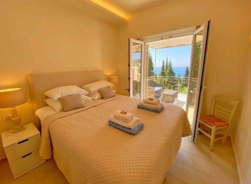 a bedroom with a bed with two towels on it at Paleopetres K-Five - Premium Double Suite - Kalami - in Kalami