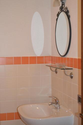 a bathroom with a sink and two mirrors on the wall at B&B Pane e Rose in San Miniato
