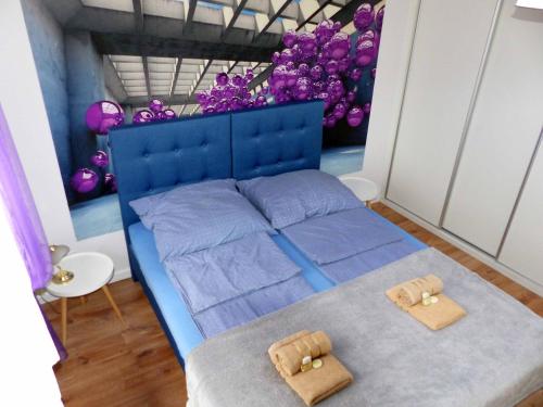 a bedroom with a blue bed with two towels on it at Apartament Kraszewskiego in Bytom