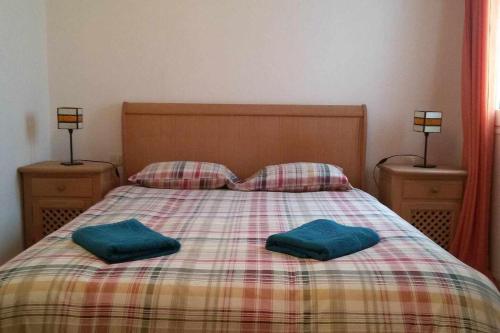 a bed with two blue pillows on top of it at Famara Sweet Home in Famara
