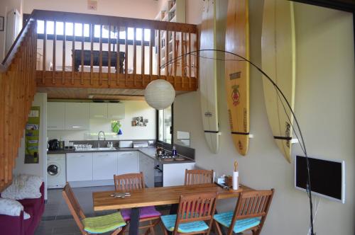 cocina y comedor con mesa de madera y sillas en Appartement Duplex RS Tursan Pour 5 Personnes Proche De La Plage Des Bourdaines en Seignosse