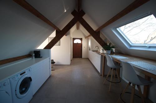 eine Waschküche mit Waschmaschine und Trockner im Dachgeschoss in der Unterkunft De Heide, cozy apartment with separate entrance in Kampenhout