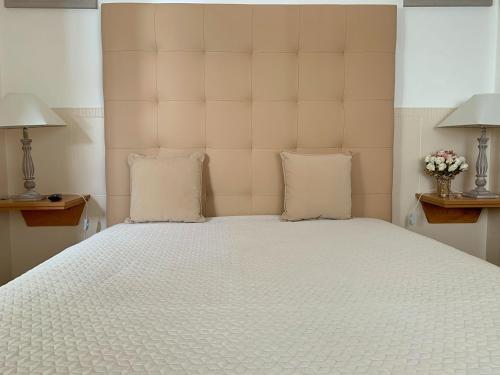 a bedroom with a large white bed with two pillows at Duarte Houses - Casa T1 - com vista mar in Nazaré