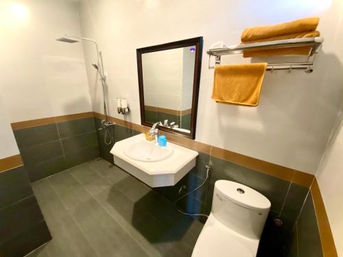 Khách sạn Hoàng Gia في Thái Bình: حمام مع مرحاض ومغسلة ومرآة