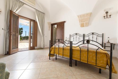 a bedroom with a bed with a yellow bedspread at Villa Martina by BarbarHouse in Carovigno