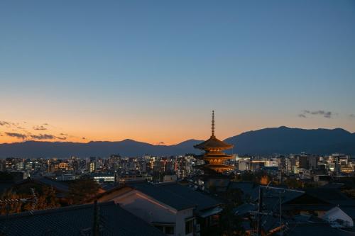 a view of a city at sunset with a pagoda at Kyo no Yado Sangen Ninenzaka in Kyoto