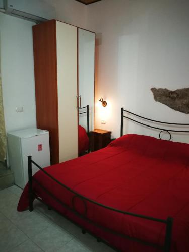Schlafzimmer mit einem Bett mit einer roten Bettdecke in der Unterkunft Casa del vico in Catania