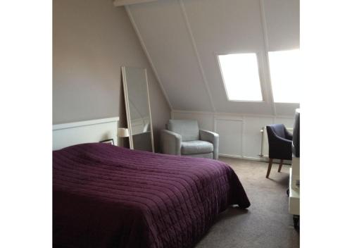 a bedroom with a purple bed and a window at Vakantiewoning Yerseke in Yerseke