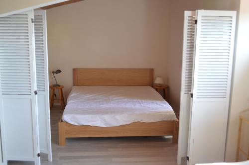 - une chambre avec un lit et 2 portes ouvertes dans l'établissement Appartement Duplex RS Tursan Pour 5 Personnes Proche De La Plage Des Bourdaines, à Seignosse