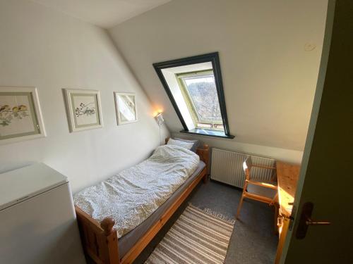 a small bedroom with a bed and a window at Borgdal in Silkeborg