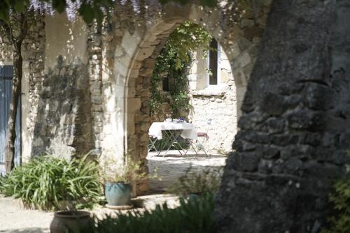 an archway in a stone building with a table in it at La Cour du Marronnier in Pont-de-Barret