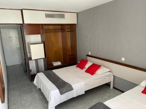 sypialnia z łóżkiem z 2 czerwonymi poduszkami w obiekcie Rasa Hotel w mieście Búzios