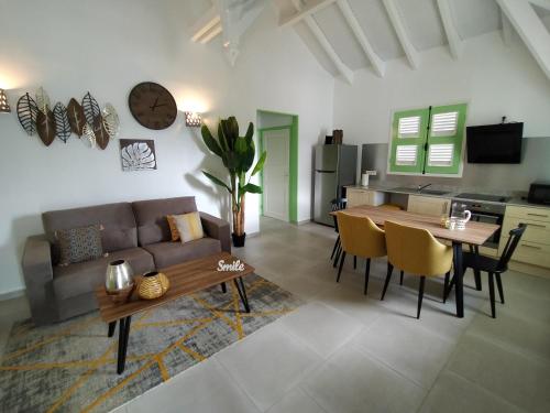 a living room with a couch and a table at Résidence Le Jardin des 4 Épices in Saint-Louis