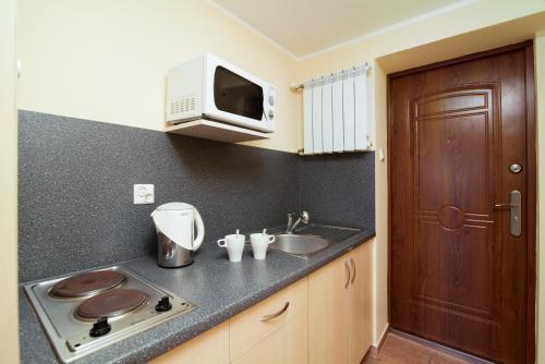 una cocina con fregadero y microondas en Super Pokoje Tom, en Władysławowo