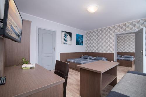 una piccola stanza con un letto e un tavolo e una camera da letto di Super Pokoje Tom a Władysławowo