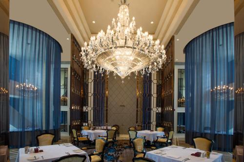 a dining room with tables and a chandelier at Dongguan Kande International Hotel in Dongguan