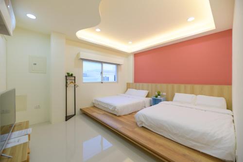 een slaapkamer met 2 bedden en een rode muur bij 小日子民宿 in Magong