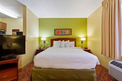 a hotel room with a bed and a flat screen tv at Extended Stay America Suites - Norfolk - Virginia Beach in Virginia Beach
