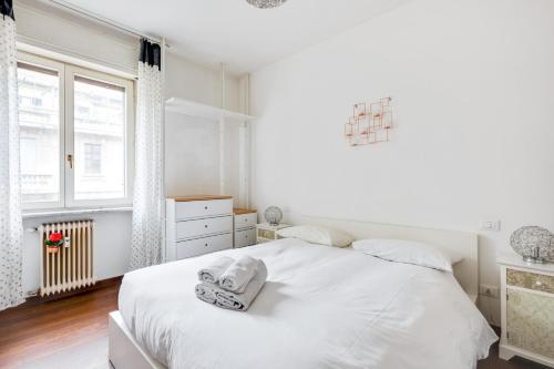 a white bedroom with a white bed and a window at Easylife - Strategic apt in Washington in Milan