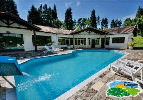 a swimming pool with chairs and a house at Vale dos Eucaliptos in Piedade
