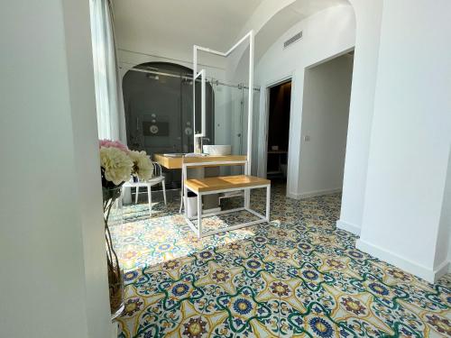 a bathroom with a vanity and a table on a tile floor at Hotel Montemare in Positano