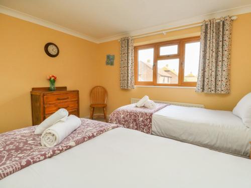 a bedroom with two beds and a window at Gabrianne in Bridport