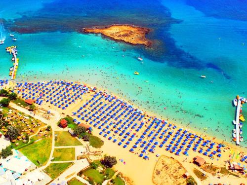 an aerial view of a beach with a group of umbrellas at Lantiana Gardens ApartHotel in Protaras