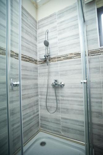 a shower with a glass door in a bathroom at Brynx Haven - Cape Coast in Cape Coast