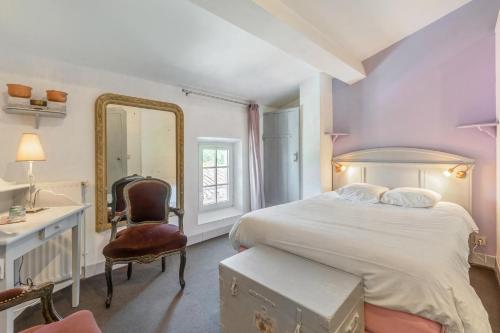 a bedroom with a bed and a mirror and a chair at Chambres d'Hôtes - Les Bujours in Saint-Georges-des-Côteaux