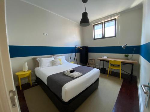 a bedroom with a bed and a desk and a table at Procyon Boutique & Suites in Ponta Delgada