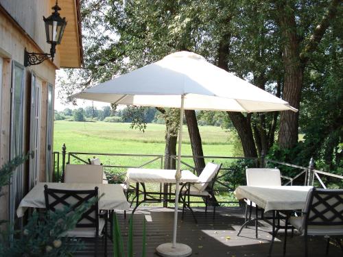 a table and chairs under an umbrella on a patio at Hotel-Restaurant Bergmühle in Bayreuth