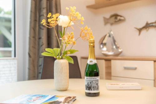 a bottle of champagne and a vase of flowers on a table at Mohnblume in Zirkow