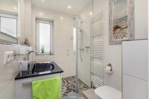 uma casa de banho branca com um lavatório e um chuveiro em Ferienwohnung Kornblume em Zirkow