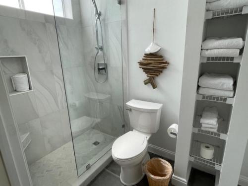 a white bathroom with a shower and a toilet at Seaspray in Santa Rosa Beach