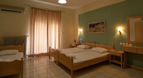 パラリア・カテリニスにあるGrand Blue Hotelのベッドルーム1室(ベッド2台、窓付)