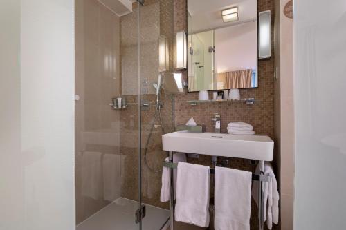 La salle de bains est pourvue d'un lavabo et d'une douche. dans l'établissement Le Pradey, à Paris