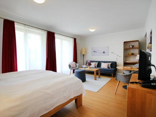 ein Schlafzimmer mit einem Bett und ein Wohnzimmer in der Unterkunft Kaiservillen Heringsdorf - 1-Raum-Ferienwohnung mit Balkon D113 in Heringsdorf