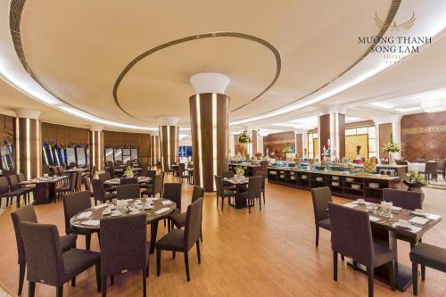 un restaurante con mesas y sillas y un gran techo en Muong Thanh Luxury Song Lam Hotel en Vinh