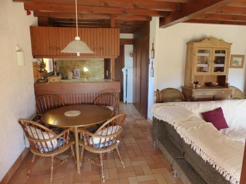 eine Küche und ein Wohnzimmer mit einem Tisch und einem Sofa in der Unterkunft La Maison Des Moineaux Entre Lac Et Ocean Pour 6 Personnes in Hossegor