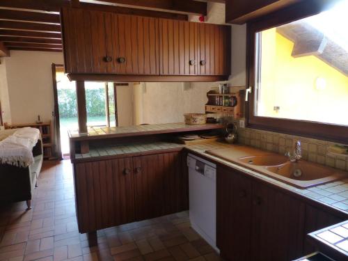 eine Küche mit Holzschränken, einem Waschbecken und einem Fenster in der Unterkunft La Maison Des Moineaux Entre Lac Et Ocean Pour 6 Personnes in Hossegor