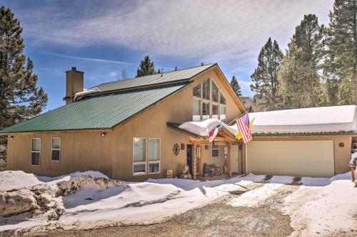 a house in the snow with a flag at Expansive Angel Fire Retreat 1 Mi to Fishing! in Angel Fire