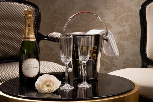 - une bouteille de champagne et deux verres sur une table dans l'établissement Le Pradey, à Paris