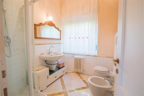 y baño con lavabo y aseo. en Casa con Giardino a 100 metri dal centro storico, en Lucignano