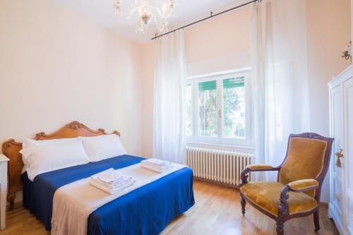 a bedroom with a bed and a chair and a window at Casa con Giardino a 100 metri dal centro storico in Lucignano
