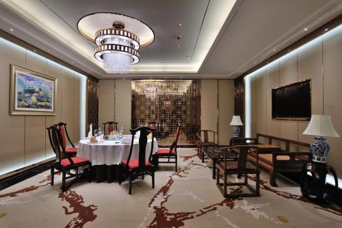 a dining room with a table and chairs and a chandelier at Dongguan Kande International Hotel in Dongguan