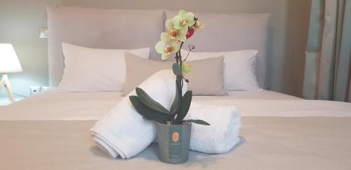 a vase with a plant on a bed with towels at Villa Marelia apartments in Aliveri