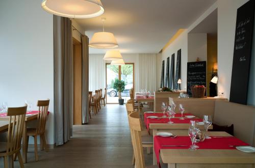 um restaurante com mesas e cadeiras vermelhas e uma sala de jantar em WeinKulturgut Longen-Schlöder em Longuich