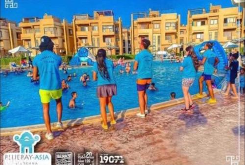a group of people standing in the water at a swimming pool at Chalet in Bluebay Asia Resort Ain Sokhna in Ain Sokhna