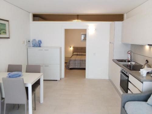 a kitchen and living room with a table and a room with a bed at Residence La Cioca in Malcesine