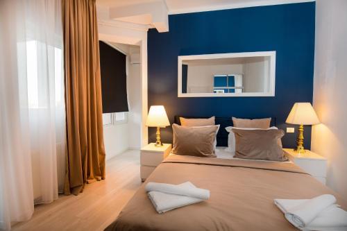 a bedroom with a blue wall and a large bed at Metropole Apartments Old Center in Bucharest
